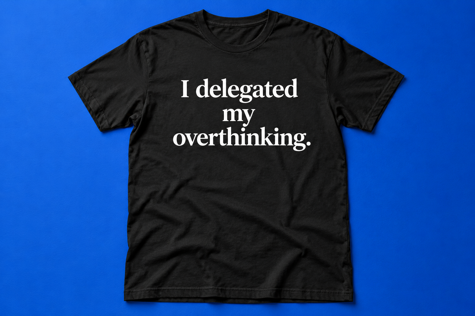 Concept mockup of a black T-shirt with white lettering: I delegated my overthinking.